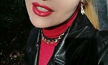 In pubblico, una splendida bionda usa un rossetto rosso per parlare sessualmente